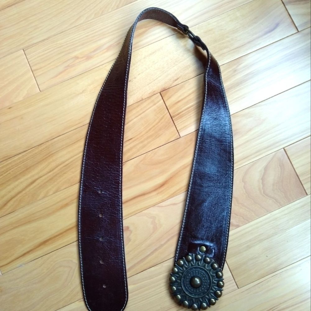 Brown patent leather belt with a round buckle